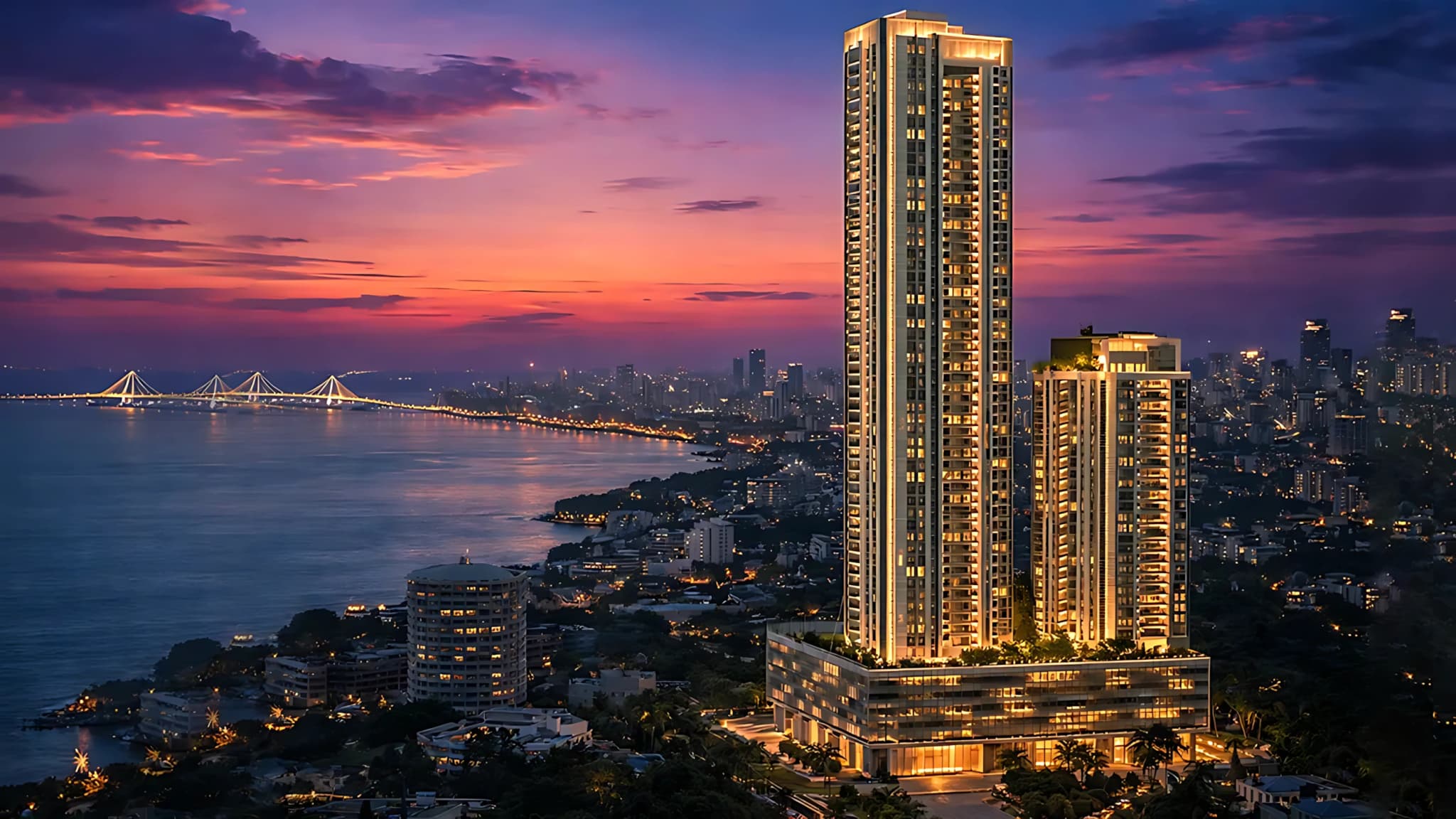 Exterior evening view of Godrej Trilogy skyscraper overlooking the ocean and city lights during twilight